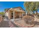This backyard features a covered patio with furniture, desert landscaping and a beautiful shade tree at 2152 Mountain City St, Henderson, NV 89052
