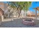 This backyard features desert landscaping, a fire pit and a beautiful shade tree at 2152 Mountain City St, Henderson, NV 89052