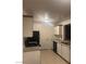 Bright kitchen with white cabinets, black appliances, and tile flooring at 220 Mission Newport Ln # 201, Las Vegas, NV 89107