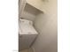 Compact laundry area with a white washing machine and shelving at 220 Mission Newport Ln # 201, Las Vegas, NV 89107