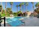 Community pool with clear blue water surrounded by lush landscaping at 220 Mission Newport Ln # 201, Las Vegas, NV 89107