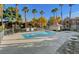 Community pool area with lounge chairs and palm trees at 220 Mission Newport Ln # 201, Las Vegas, NV 89107