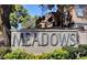 The Meadows community entrance with flower beds and mature trees at 220 Mission Newport Ln # 201, Las Vegas, NV 89107