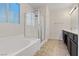 Bathroom featuring a tub with a shower, dark cabinets and tile floors at 227 Palmarosa St, Henderson, NV 89015