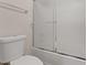 Bright bathroom with a toilet and bathtub with frosted glass doors at 227 Palmarosa St, Henderson, NV 89015