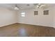 Spacious bedroom featuring wood-look floors, neutral walls, a window and two ceiling fans at 227 Palmarosa St, Henderson, NV 89015