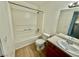 A full bath features a tub, updated vanity, wood look flooring, and large mirror reflecting the window at 2524 Charleville Ave # 102, Las Vegas, NV 89106