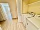 Modern laundry room features a white washer and dryer, bi-fold door and space for additional storage at 2524 Charleville Ave # 102, Las Vegas, NV 89106