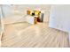 Open-concept living space with wood-look flooring, and adjacent kitchen with breakfast bar at 2524 Charleville Ave # 102, Las Vegas, NV 89106