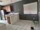 Bright kitchen with tile flooring, modern stainless steel refrigerator and tiled countertop and dark accent wall at 2803 Exulted Valley Ave, North Las Vegas, NV 89032
