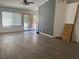 Spacious living room with window and sliding glass door offering natural light, wood-look flooring, and ceiling fan at 2803 Exulted Valley Ave, North Las Vegas, NV 89032