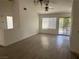 Open-concept living room with high ceilings, neutral paint, window, sliding glass door, and wood-look flooring at 2803 Exulted Valley Ave, North Las Vegas, NV 89032
