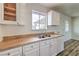 Bright kitchen featuring a stainless steel sink with window, white cabinetry, and hard surface countertops at 2825 Berg St, North Las Vegas, NV 89030