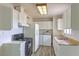 Bright kitchen featuring a gas range, white cabinetry, stainless steel sink, and convenient in-kitchen laundry at 2825 Berg St, North Las Vegas, NV 89030