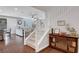 View of the light-filled foyer, staircase, and open-concept living area with hardwood floors, neutral decor, and modern furnishings at 305 Rezzo St, Las Vegas, NV 89138