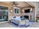 Inviting covered patio with fireplace, TV, ceiling fan, and comfortable cushioned seating area for relaxation at 305 Rezzo St, Las Vegas, NV 89138