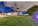 Spacious backyard with lush lawn, a volleyball net, a patio, and illuminated landscape, perfect for outdoor activities at 3175 S Torrey Pines Dr, Las Vegas, NV 89146