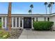 Charming single-story home featuring a rock garden, mature trees, and a striking double-door entryway with a security camera at 3175 S Torrey Pines Dr, Las Vegas, NV 89146