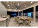 Modern outdoor kitchen and dining area featuring sleek countertops, grill, and views of the backyard pool and patio at 3175 S Torrey Pines Dr, Las Vegas, NV 89146