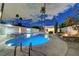 Backyard pool and spa area are illuminated with blue and purple lights against the evening sky with lounge chairs at 3175 S Torrey Pines Dr, Las Vegas, NV 89146