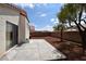 Spacious backyard with a concrete patio, mature tree, and a block wall for privacy at 343 Dune Ridge Ave, North Las Vegas, NV 89031