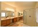 Well-lit bathroom with dual sinks, framed mirrors, and a glass-enclosed shower at 343 Dune Ridge Ave, North Las Vegas, NV 89031