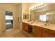 Bright bathroom featuring double sinks, a large mirror, and neutral-toned flooring at 343 Dune Ridge Ave, North Las Vegas, NV 89031