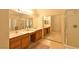 Well-lit bathroom featuring double sinks, wood cabinets, and a glass-enclosed shower at 343 Dune Ridge Ave, North Las Vegas, NV 89031