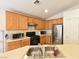 Traditional kitchen with an island sink, wooden cabinets, and black appliances at 343 Dune Ridge Ave, North Las Vegas, NV 89031
