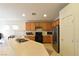 Traditional kitchen featuring wooden cabinets, black appliances, and a stainless steel refrigerator at 343 Dune Ridge Ave, North Las Vegas, NV 89031