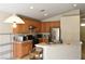Kitchen area features stainless steel appliances, wood cabinets, and an island with sink and dining area at 343 Dune Ridge Ave, North Las Vegas, NV 89031