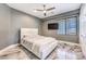 Modern bedroom with a tufted headboard bed, contemporary ceiling fan, and large window with blinds at 3552 Coventry Gardens Dr, Las Vegas, NV 89135