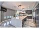 Modern kitchen with a large central island, stylish pendant lighting, and stainless steel appliances with seamless countertops at 3552 Coventry Gardens Dr, Las Vegas, NV 89135