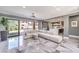 Open-concept living room with modern furnishings, marble flooring, and seamless access to outdoor pool area at 3552 Coventry Gardens Dr, Las Vegas, NV 89135