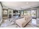 Modern living room with large sectional sofa, sleek fireplace, marble floors and sliding glass doors to the patio at 3552 Coventry Gardens Dr, Las Vegas, NV 89135