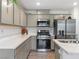 Modern kitchen featuring stainless steel appliances, quartz countertops, and shaker cabinets at 3585 Arcadian Sea St, Las Vegas, NV 89106