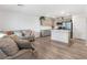 Open-concept living room with a modern kitchen featuring stainless steel appliances and a breakfast bar at 3585 Arcadian Sea St, Las Vegas, NV 89106