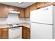 Bright kitchen includes a white refrigerator, stove, and abundant wooden cabinet space at 3740 Desert Marina Dr # 2, Laughlin, NV 89029