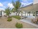 Secluded backyard featuring a covered patio, artificial grass, bench, and mature landscaping at 389 Umbria Way, Henderson, NV 89014
