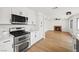 Updated kitchen equipped with stainless steel appliances, stone counters and sleek white cabinets at 389 Umbria Way, Henderson, NV 89014