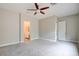 Spacious carpeted bedroom featuring a ceiling fan and ensuite bathroom entrance at 4 Chatmoss Rd, Henderson, NV 89052