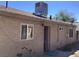 Exterior backyard area with beige stucco walls, a dog door and a blue bicycle at 400 National St, Henderson, NV 89015