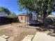 Backyard with a trampoline and shed under a large tree, offering a fun and shaded play area at 400 National St, Henderson, NV 89015