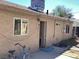 Exterior backyard area with beige stucco walls, a dog door and a blue bicycle at 400 National St, Henderson, NV 89015