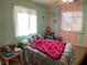 Cozy bedroom with colorful striped walls, large windows, and a soft, inviting bedspread at 400 National St, Henderson, NV 89015