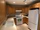 Functional kitchen with oak cabinets, tile floors, sink and white appliances at 400 National St, Henderson, NV 89015