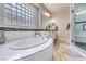 Well-lit bathroom with a soaking tub, tiled backsplash, and sleek fixtures for a modern, luxurious feel at 409 Lake Windemere St, Las Vegas, NV 89138