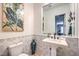 Charming powder room featuring a pedestal sink, floral tile accents, and a decorative mirror at 409 Lake Windemere St, Las Vegas, NV 89138