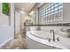Beautiful bathroom featuring a luxurious soaking tub, custom tile, and plenty of natural light at 409 Lake Windemere St, Las Vegas, NV 89138