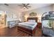 A comfortable bedroom with hardwood floors, a ceiling fan, and a view into an adjacent bathroom at 409 Lake Windemere St, Las Vegas, NV 89138